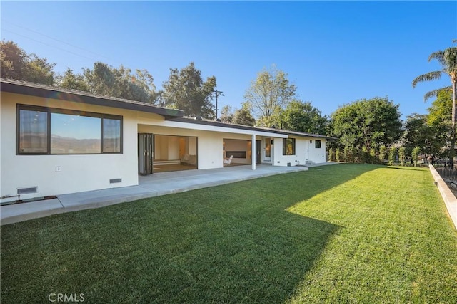 rear view of property with a patio area and a lawn