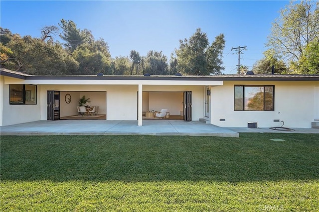 back of property featuring a patio area and a lawn