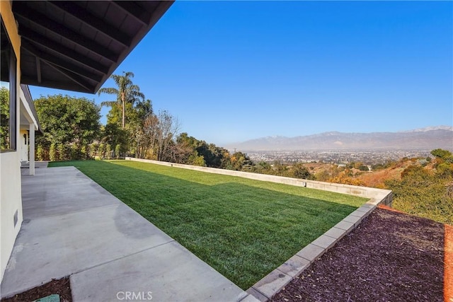 view of yard featuring a mountain view and a patio area