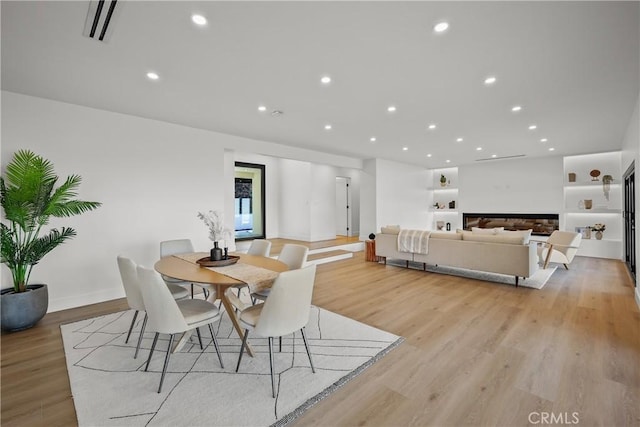 dining space featuring built in features and light hardwood / wood-style floors