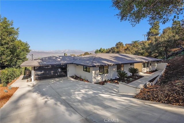 single story home with a garage and a mountain view