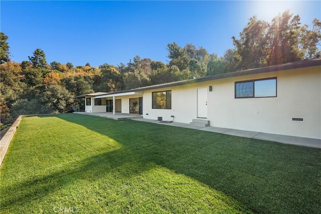 rear view of property with a yard and a patio