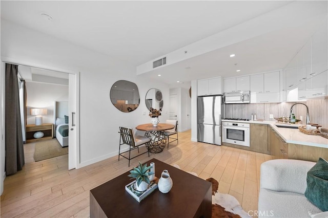 living room with light hardwood / wood-style flooring and sink