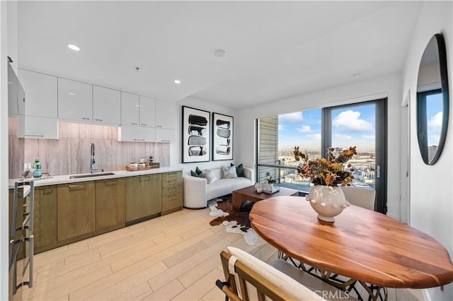 dining space with sink and light hardwood / wood-style flooring