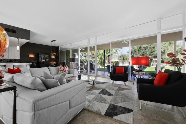 living room featuring ceiling fan, floor to ceiling windows, and a healthy amount of sunlight