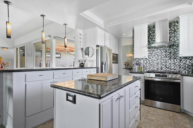 kitchen with white cabinetry, appliances with stainless steel finishes, a center island, and wall chimney exhaust hood