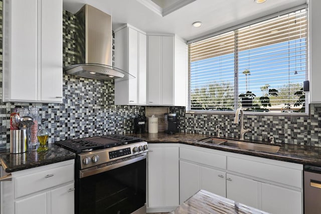 kitchen featuring sink, white cabinets, appliances with stainless steel finishes, and wall chimney exhaust hood