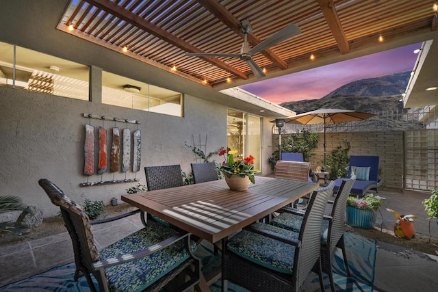 patio terrace at dusk featuring ceiling fan