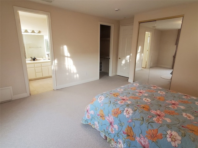 carpeted bedroom with a closet and connected bathroom