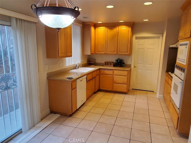 kitchen featuring a wealth of natural light, sink, white appliances, hanging light fixtures, and light tile patterned floors