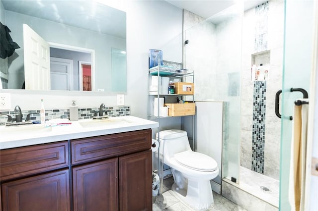 bathroom featuring decorative backsplash, toilet, a shower with door, and vanity