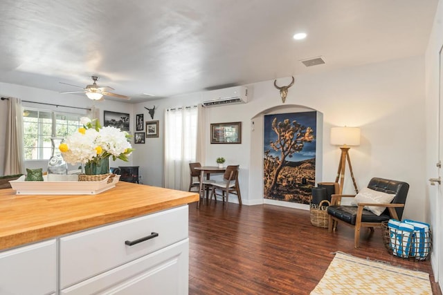 kitchen featuring white cabinetry, butcher block counters, ceiling fan, dark hardwood / wood-style floors, and a wall mounted air conditioner