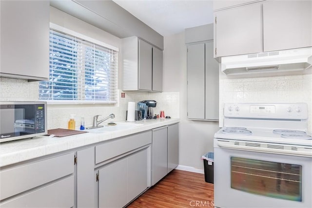 kitchen with backsplash, dark hardwood / wood-style floors, electric range, and sink