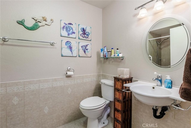 bathroom with a shower, sink, tile walls, and toilet