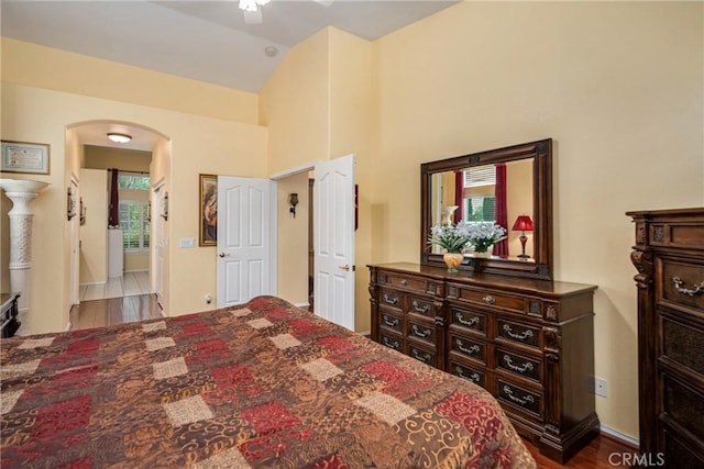 bedroom with ceiling fan, vaulted ceiling, connected bathroom, and wood-type flooring