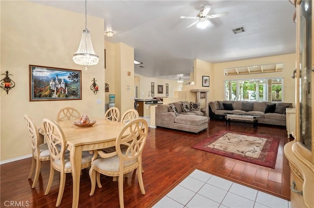 dining space featuring ceiling fan with notable chandelier and hardwood / wood-style flooring