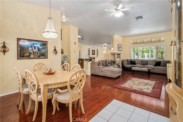 dining area featuring ceiling fan with notable chandelier and hardwood / wood-style flooring