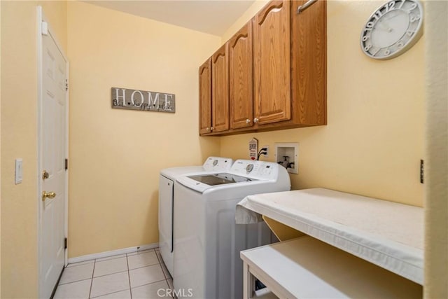 clothes washing area with cabinets, light tile patterned flooring, and independent washer and dryer