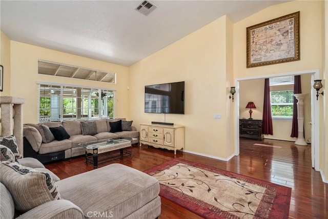 living room featuring plenty of natural light, dark hardwood / wood-style floors, and lofted ceiling