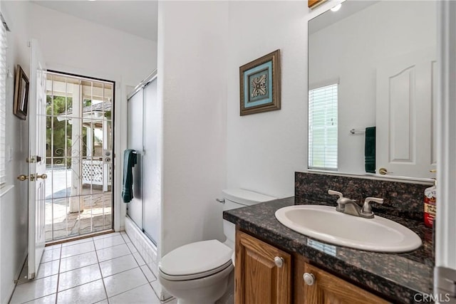 bathroom with toilet, tile patterned flooring, walk in shower, and vanity