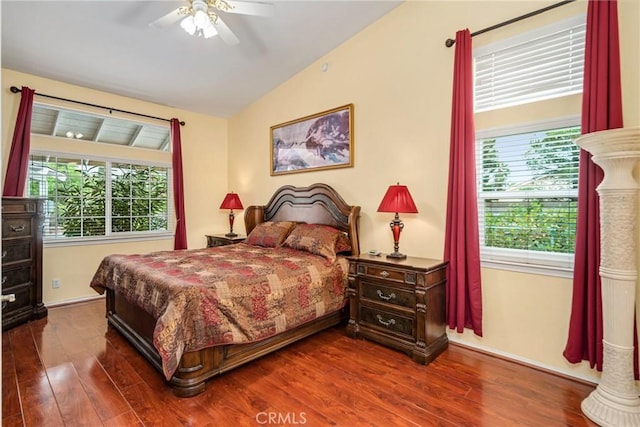 bedroom featuring ceiling fan, multiple windows, dark hardwood / wood-style floors, and vaulted ceiling