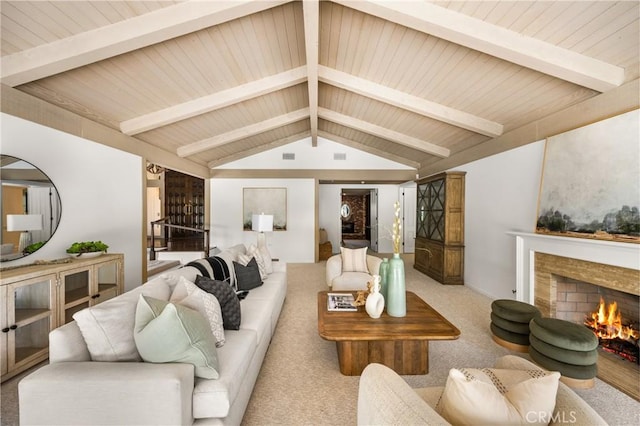 living room with lofted ceiling with beams, light colored carpet, and a high end fireplace