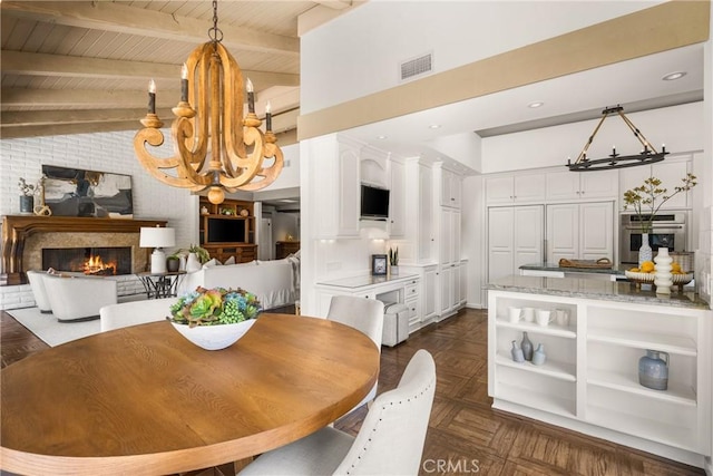 dining space featuring a notable chandelier, dark parquet flooring, wooden ceiling, and vaulted ceiling with beams