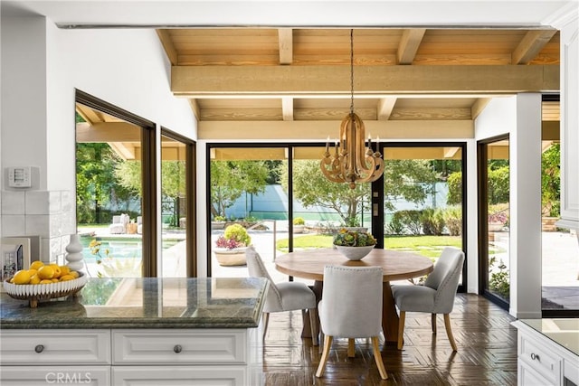 sunroom with an inviting chandelier, beam ceiling, and wooden ceiling