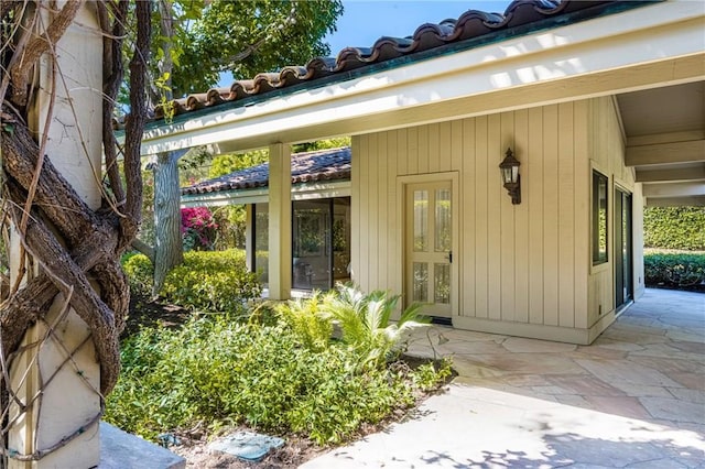 view of exterior entry with a patio area