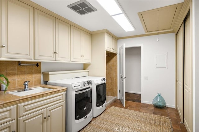 laundry room with cabinets, separate washer and dryer, and sink