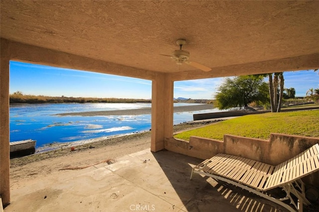 view of patio / terrace featuring ceiling fan, a beach view, and a water view