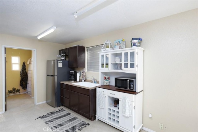 kitchen featuring stainless steel appliances, dark brown cabinetry, and sink