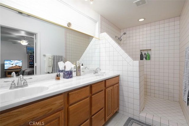 bathroom featuring ceiling fan, a shower, tile walls, and vanity