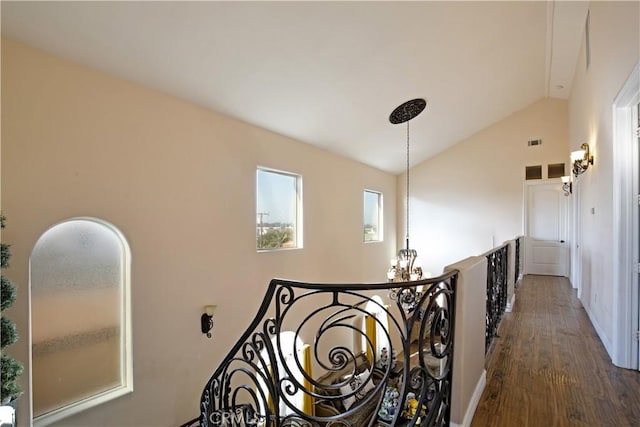 corridor featuring dark wood-type flooring and vaulted ceiling