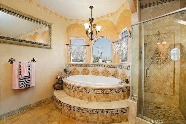 bathroom featuring a chandelier and shower with separate bathtub