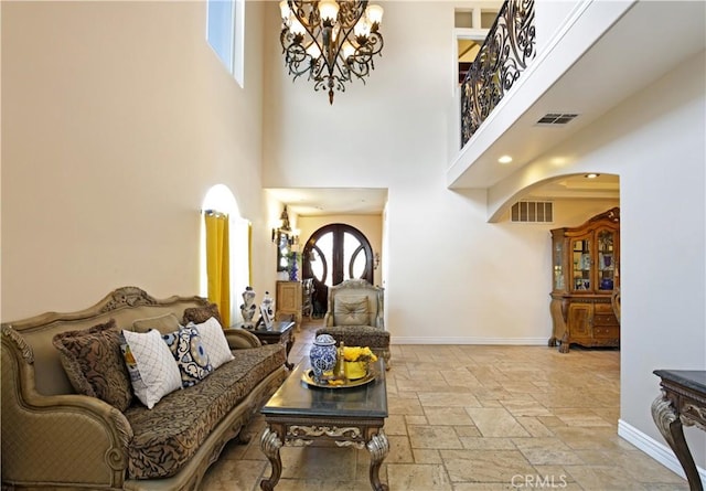 living room featuring a towering ceiling and an inviting chandelier