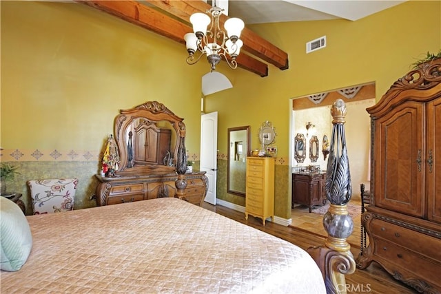 bedroom featuring hardwood / wood-style flooring, beamed ceiling, and an inviting chandelier