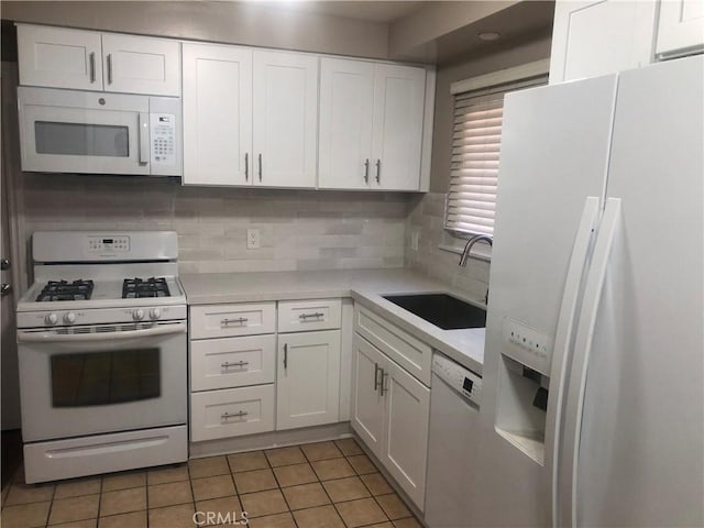 kitchen featuring white cabinets, white appliances, light tile patterned floors, and sink