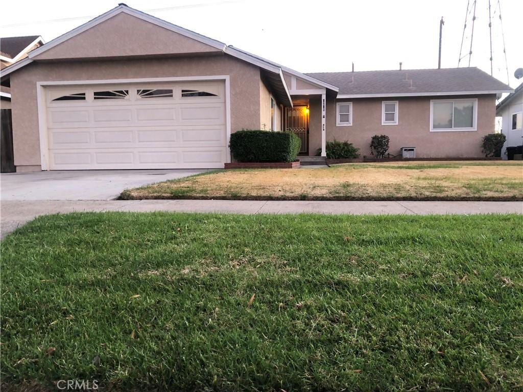 ranch-style home featuring a front yard and a garage