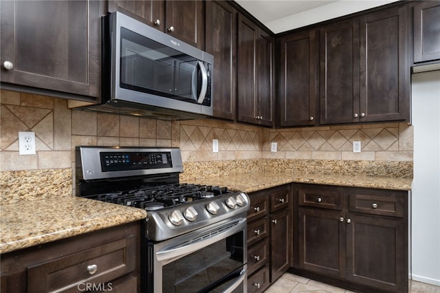 kitchen with appliances with stainless steel finishes, backsplash, light stone counters, and dark brown cabinetry