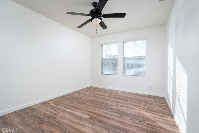 unfurnished room featuring dark wood-type flooring and ceiling fan