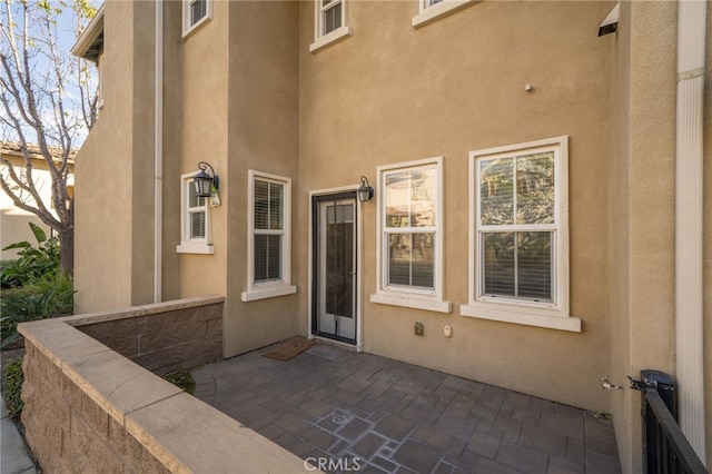 view of exterior entry featuring a patio area