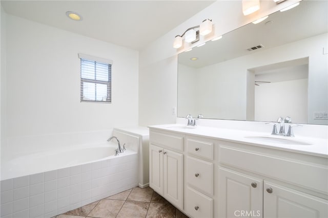 bathroom with vanity, tile patterned floors, and a relaxing tiled tub