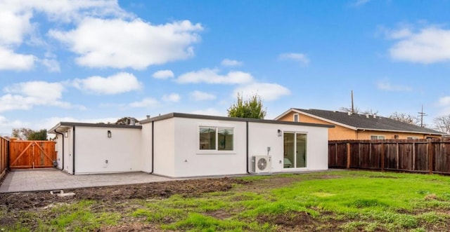 rear view of property with a lawn, ac unit, and a patio