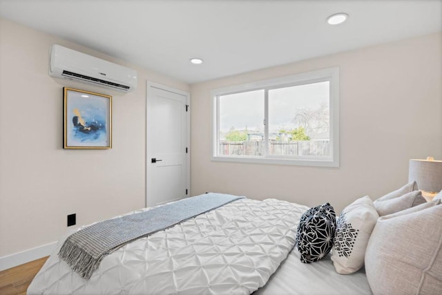 bedroom featuring a wall mounted AC and wood-type flooring