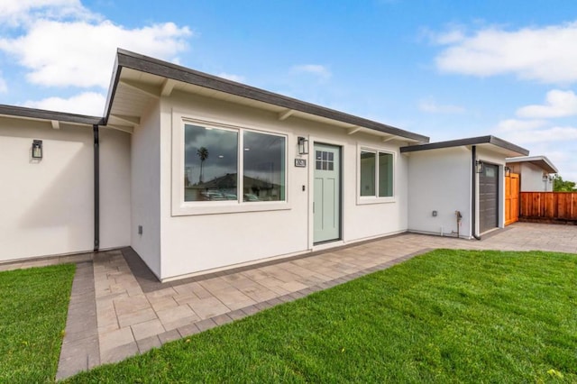 back of property featuring a patio area and a yard