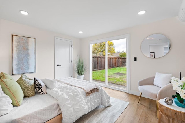 bedroom with access to exterior and light hardwood / wood-style flooring