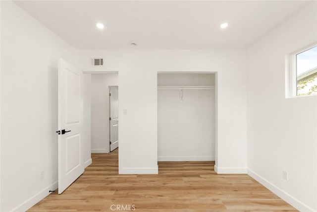 unfurnished bedroom featuring a closet and light hardwood / wood-style floors