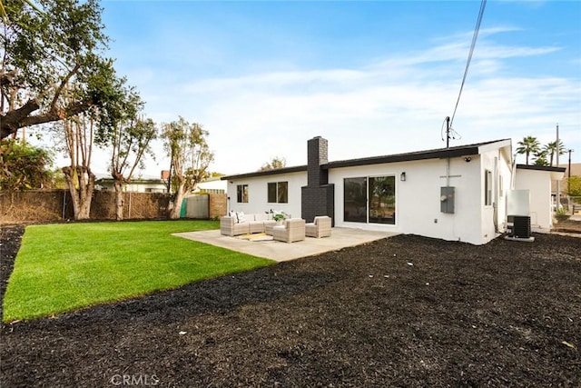 rear view of property with a patio area, an outdoor living space, and a lawn