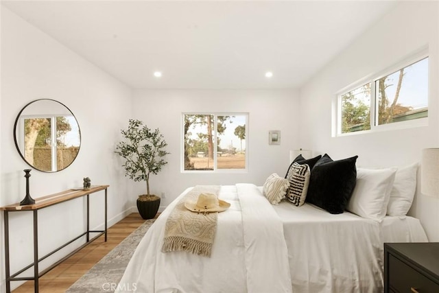 bedroom with light hardwood / wood-style floors and multiple windows